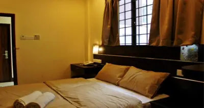 a bedroom with a bed with two pillows and a window at GOLDEN PALACE in Kuala Lumpur