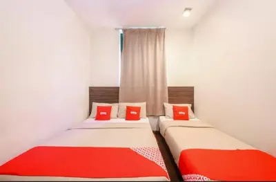 two twin beds with red pillows in a room at GOLDEN PALACE in Kuala Lumpur