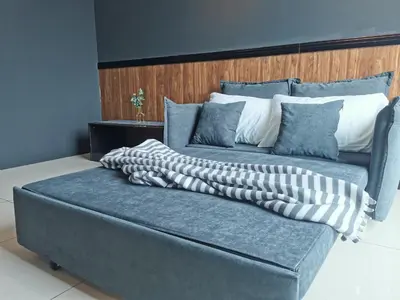 a blue couch with two pillows on top of it at OPUS RESIDENCE KL I HomeBrickz in Kuala Lumpur