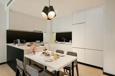 a white kitchen with a table and chairs at Ascott Star KLCC Kuala Lumpur in Kuala Lumpur