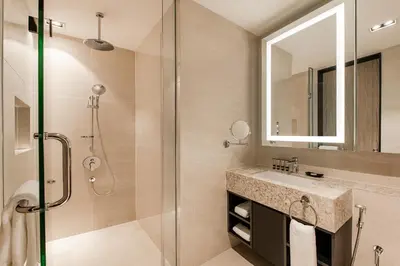 a bathroom with a shower and a sink and a mirror at Ascott Star KLCC Kuala Lumpur in Kuala Lumpur