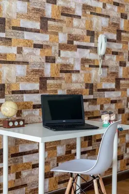 a laptop computer sitting on a desk in front of a brick wall at Cozy Regalia KL 吉隆玻 LRT & KTM @1 Parking & WIFI in Kuala Lumpur