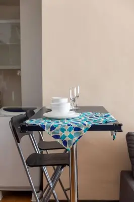 a table with a plate and wine glasses on it at Cozy Regalia KL 吉隆玻 LRT & KTM @1 Parking & WIFI in Kuala Lumpur