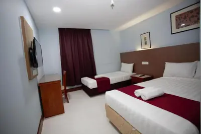 a hotel room with two beds and a television at Orkid Hills Hotel at Bukit Bintang in Kuala Lumpur