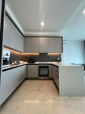 a kitchen with white cabinets and a white counter top at Opus Residence KL by EUcation Home in Kuala Lumpur