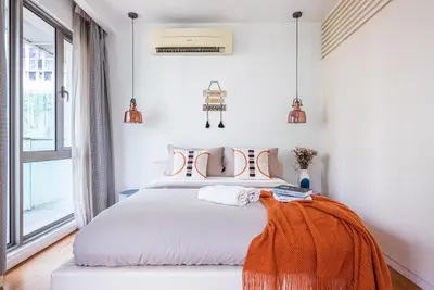 a bedroom with a bed with an orange blanket on it at FAIRLANE 2mins walk to Bukit Bintang BEST SUNSET view 2BR 8-1 WIFI 100mbps in Kuala Lumpur