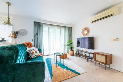 a living room with a green couch and a television at FAIRLANE 2mins walk to Bukit Bintang BEST SUNSET view 2BR 8-1 WIFI 100mbps in Kuala Lumpur