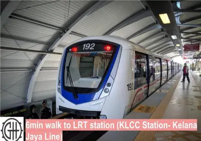 a train is pulling into a train station at GH KLCC Apartment by GuestHouse in Kuala Lumpur