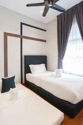 two beds in a bedroom with a ceiling fan at GH KLCC Apartment by GuestHouse in Kuala Lumpur