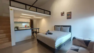 a bedroom with a bed and a table and a kitchen at KL Sentral Loft, EST Bangsar #1, LRT in Kuala Lumpur