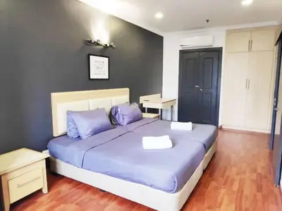 a bedroom with a large bed with blue pillows at Eco One Bedroom Apartment @ Jalan Ampang, 3 pax in Kuala Lumpur