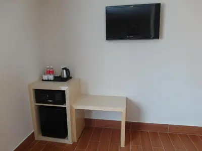 a room with a table and a tv on a wall at Metro Hotel @ KL Sentral in Kuala Lumpur