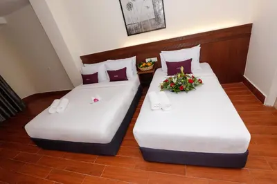 two beds in a hotel room with flowers on them at Metro Hotel @ KL Sentral in Kuala Lumpur