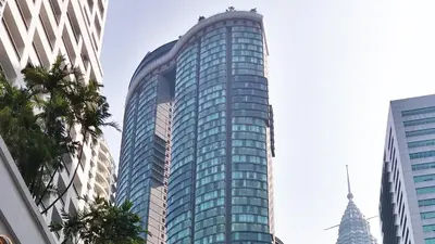 a tall glass building in a city at Private Room at Sky Suites KLCC by iRent365 in Kuala Lumpur