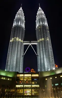 two tall buildings are lit up at night at FKI INTERNATIONAL HOTEL in Kuala Lumpur