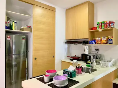 a kitchen with a refrigerator and some bowls on a counter at Private Jacuzzi Staycation at KL City 152 in Kuala Lumpur