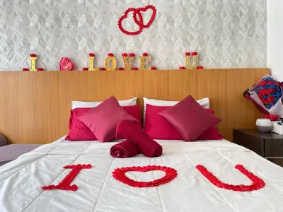 a bed with red pillows with the word love written on it at Private Jacuzzi Staycation at KL City 152 in Kuala Lumpur