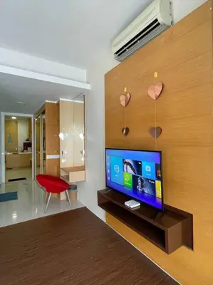a living room with a television and a red chair at Private Jacuzzi Staycation at KL City 1014 in Kuala Lumpur