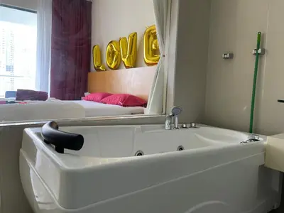 a bathroom with a bath tub and a mirror at Private Jacuzzi Staycation at KL City 921 in Kuala Lumpur