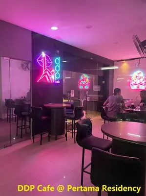 a restaurant with tables and chairs and a neon sign at Private Jacuzzi Staycation at KL City 921 in Kuala Lumpur