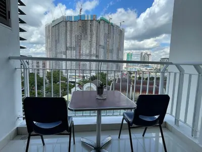 a table and chairs on a balcony with a view of a city at Private Jacuzzi Staycation at KL City 921 in Kuala Lumpur
