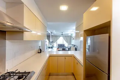 a kitchen with white cabinets and a stove top oven at Rex Ollie @ Myhabitat Condominium in Kuala Lumpur