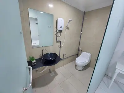 a bathroom with a toilet and a sink and a mirror at ONE AMPANG HOTEL in Ampang