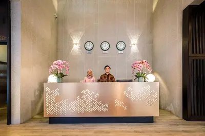 two people standing behind a reception desk in a lobby at Santa Grand Classic Kuala Lumpur, Chinatown in Kuala Lumpur