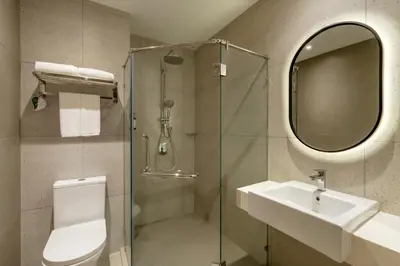 a bathroom with a shower and a sink and a mirror at lyf Chinatown Kuala Lumpur in Kuala Lumpur
