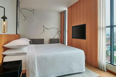 a bedroom with a white bed and a flat screen tv at Fairfield by Marriott Chow Kit Kuala Lumpur in Kuala Lumpur