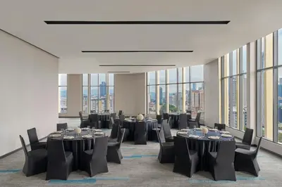 a conference room with tables and chairs and windows at Fairfield by Marriott Chow Kit Kuala Lumpur in Kuala Lumpur