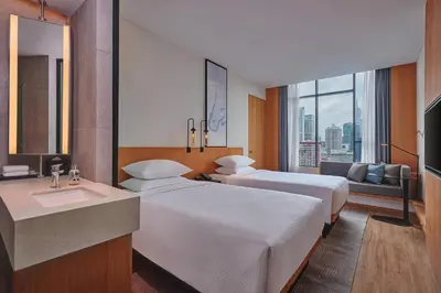 a hotel room with two beds and a sink at Fairfield by Marriott Chow Kit Kuala Lumpur in Kuala Lumpur