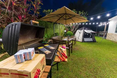a backyard with a tent and a grill and an umbrella at 25P Enchanting Bungalow Retreat - Mystical Garden,Petaling Jaya by Verano in Petaling Jaya