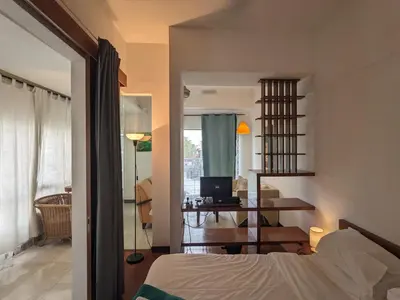 a bedroom with a bed and a desk with a laptop at Damansara Suites in Kuala Lumpur
