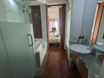 a bathroom with two sinks and a walk in shower at Damansara Suites in Kuala Lumpur