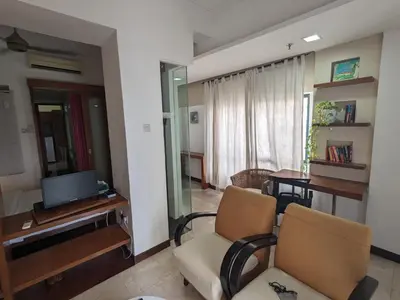 a living room with two chairs and a television at Damansara Suites in Kuala Lumpur