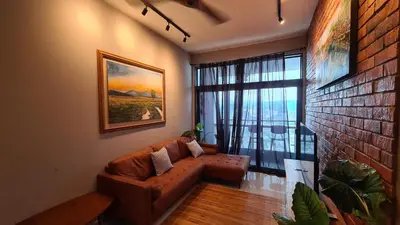 a living room with a couch and a large window at Rumah Kampong Bharu near KLCC (3Rooms) in Kuala Lumpur