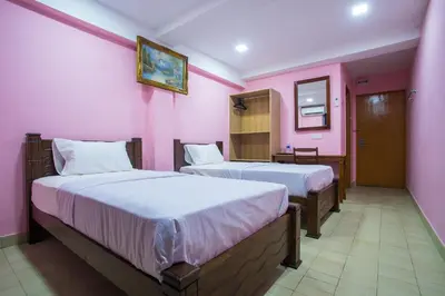 two beds in a room with pink walls at MK Inn Hotel in Kuala Lumpur