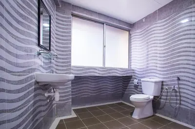 a bathroom with a toilet and a sink and a window at MK Inn Hotel in Kuala Lumpur