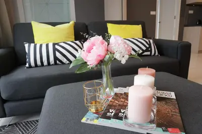 a vase of pink flowers and candles on a table at MyCribKL The Robertson 2 Bedroom Bukit Bintang in Kuala Lumpur
