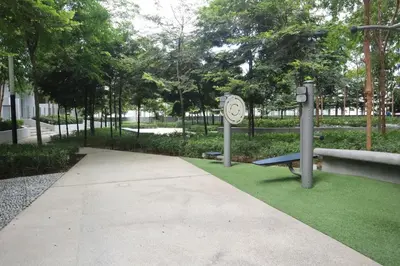 a walkway with a clock and a bench and grass at MyCribKL The Robertson 2 Bedroom Bukit Bintang in Kuala Lumpur