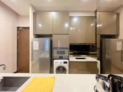 a kitchen with stainless steel appliances and a washer and dryer at Nana's at Dorsett Residence Bukit Bintang in Kuala Lumpur