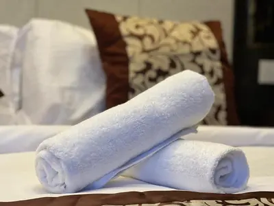 a stack of towels sitting on a bed at Dorsett Residence Service Suite At Bukit Bintang KL in Kuala Lumpur