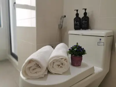 a bathroom with towels on a shelf with a toilet at Continew Residence by HomeBrickz in Kuala Lumpur