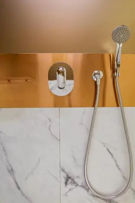 a shower in a bathroom with white marble at WOLO Kuala Lumpur in Kuala Lumpur