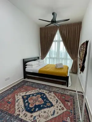 a bedroom with a bed with a fan and a rug at Legasi Kampung Baru apartment by rumahrehat in Kuala Lumpur