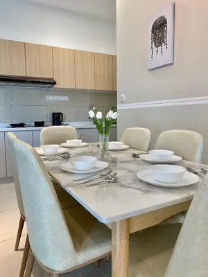 a dining room table with white dishes and flowers on it at TR Residence Near Titiwangsa LRT By Iconique in Kuala Lumpur