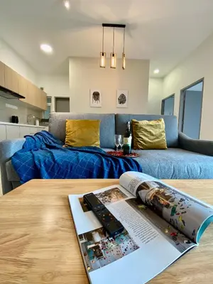 a living room with a couch and a table with a magazine at TR Residence Near Titiwangsa LRT By Iconique in Kuala Lumpur