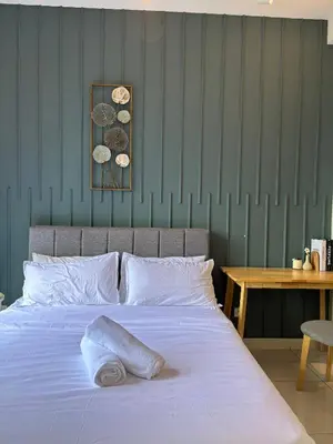 a bedroom with a white bed and a table at Modern Suites at Arte Mont Kiara BY Iconique in Kuala Lumpur
