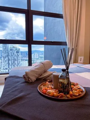 a plate of food on a bed with a window at Modern Suites at Arte Mont Kiara BY Iconique in Kuala Lumpur